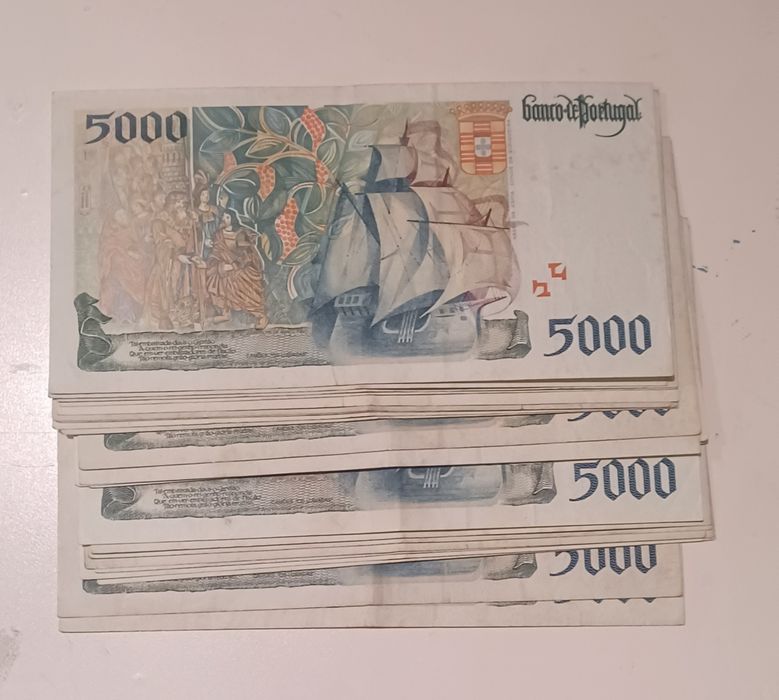 Notas de 5000 escudos abaixo do valor facial.