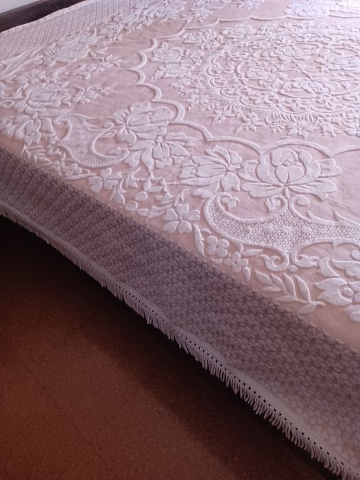 Colcha de de casal cor de rosa com desenhos florais.