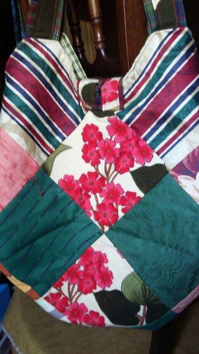 saco/mala com quadrados de tecido. Tem bolsos interiores