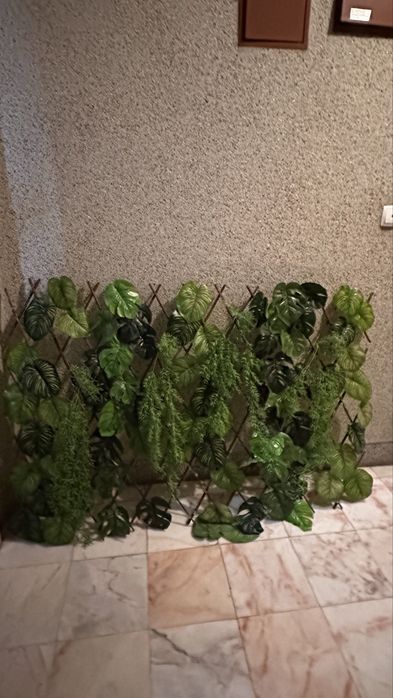 treliça de madeira expansível com plantas artificiais.