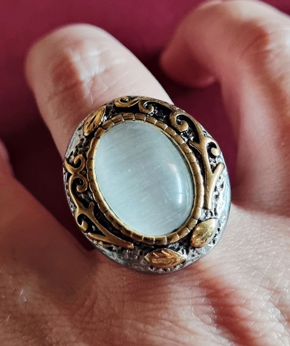 Anel bicolor, em aço, com grande pedra oval "olho de gato". T19/20