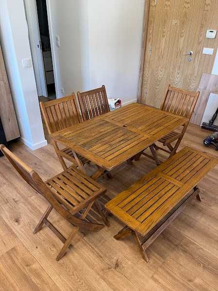 Mesa com quarto cadeiras e um banco corrido