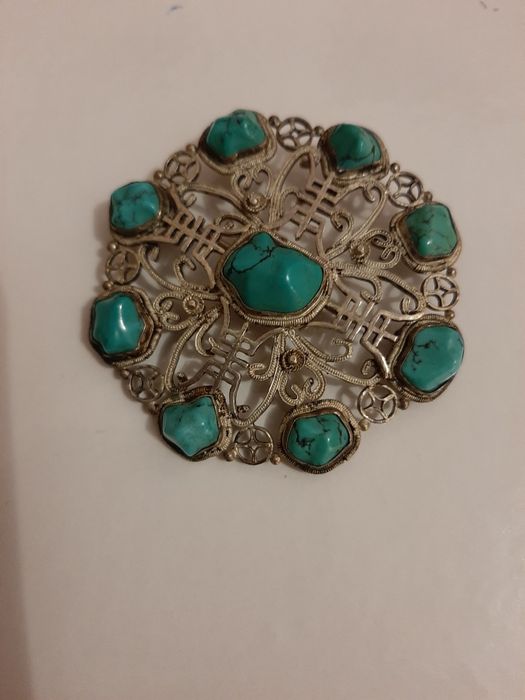 Vendo alfinete redondo prateado com pedras azuis turquesa