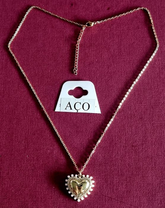 Colar dourado, em aço, com pingente formato coração rodeado de zirconias e pérolas