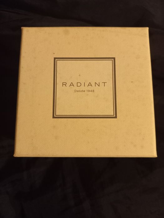 Relógio prateado e dourado com zirconias à volta do mostrador.