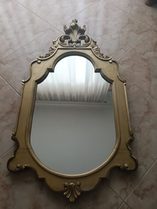 Espelho em excelente estado com moldura em madeira talhada dourada.