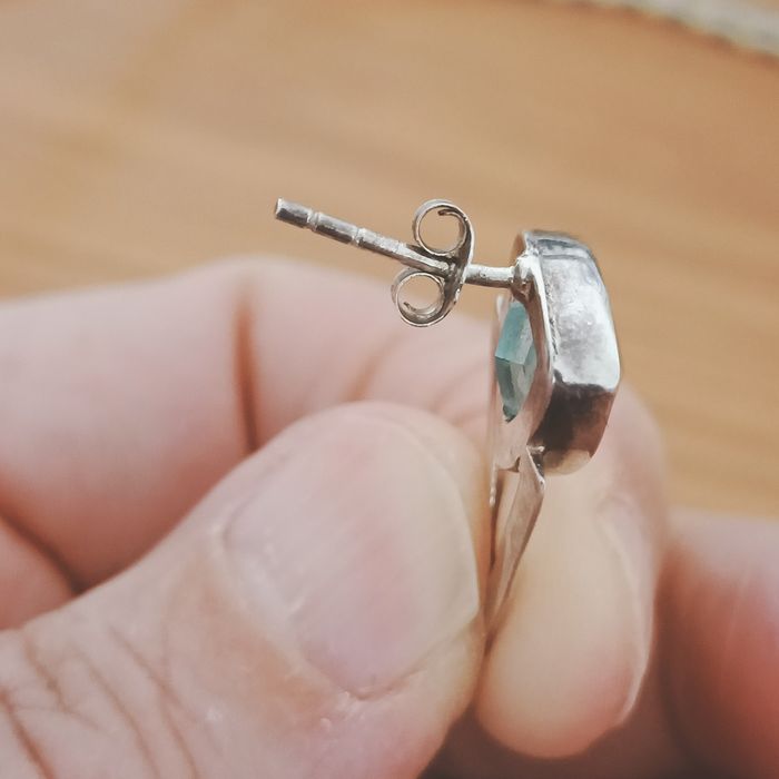 Brincos em prata com contraste e pedra azul.