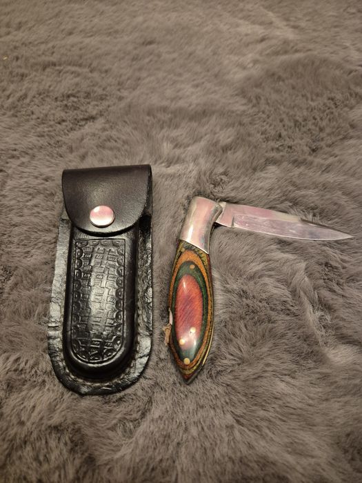 Nóż składany z głownią o wzorze damasceńskim.
Rękojeść z naturalnej ko