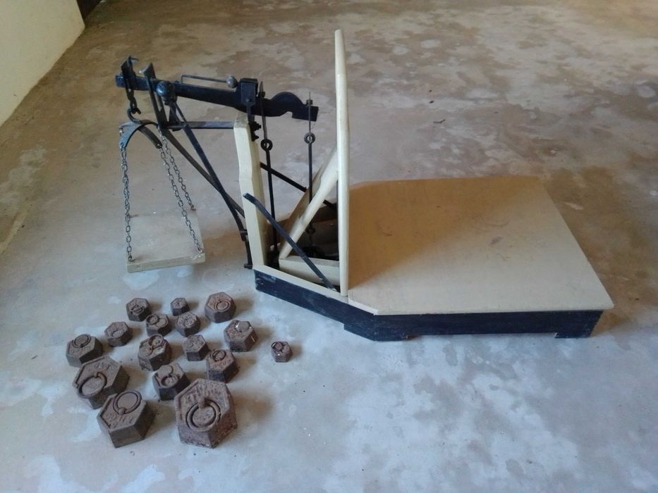 Balança decimal e pesos em perfeitas condições.