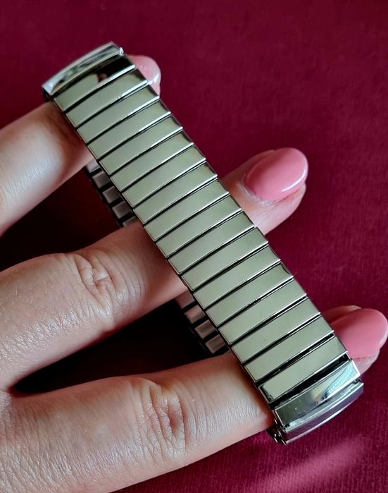 Pulseira elástica prateada, em aço inoxidável.