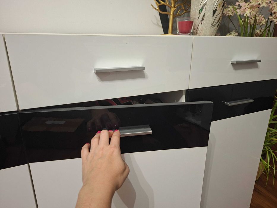 Komoda biala polysk z czarnymi dodatkami.