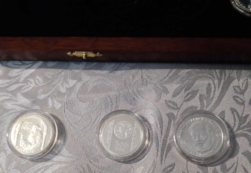 Coleção de sete moedas em pratas, com caixa em madeira