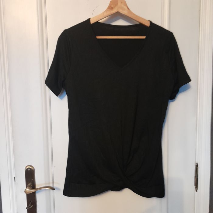 Blusa preta mangas curtas, traçada à frente na zona do cós, decote V