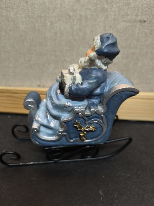 Pai Natal em trenó azul
Figura decorativa de Pai Natal sentado num tre