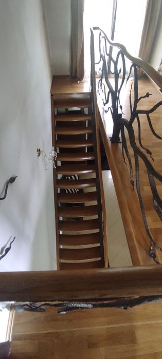 Piękne dębowe schody z kuta barierka i giętą poręczą