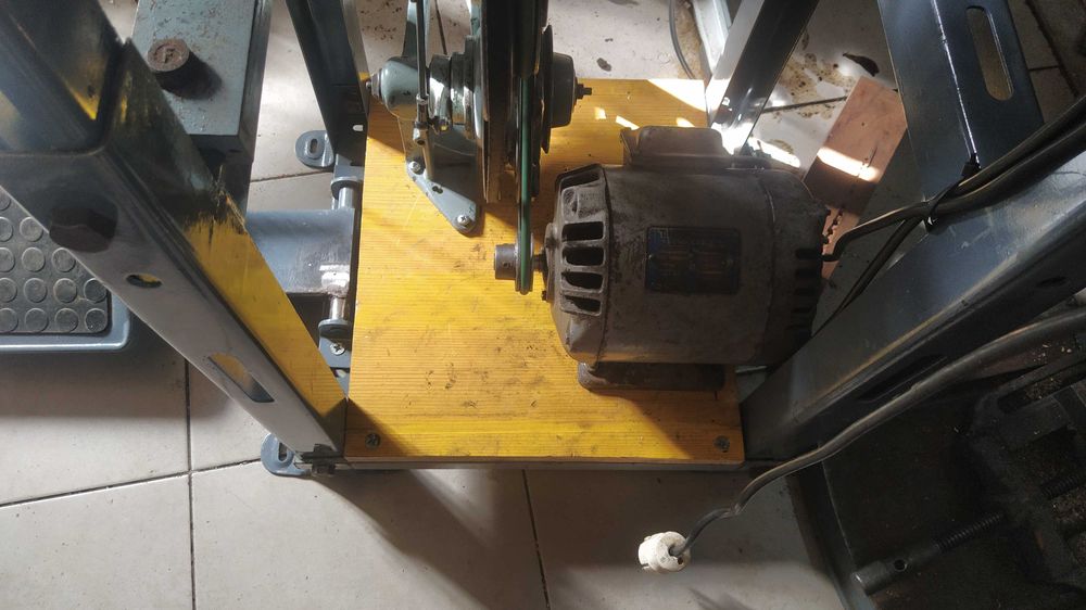 Uma máquina de braço Singer para coser pele e tecidos grossos .