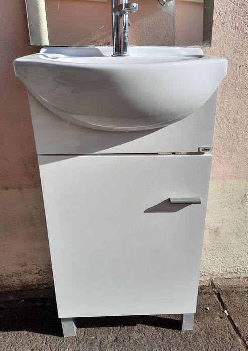 Pequeno móvel com lavatório, torneira e espelho