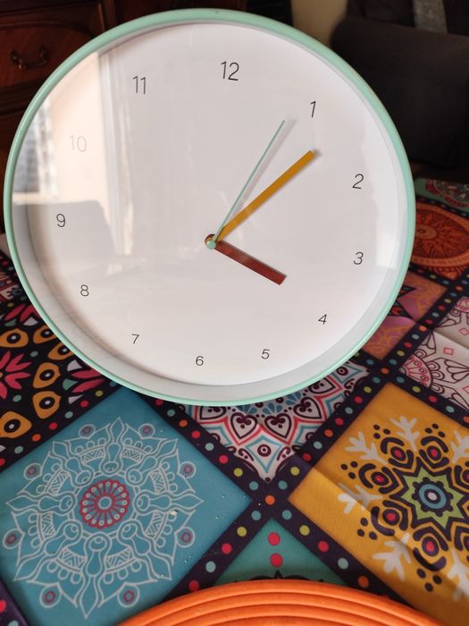 Relógio de parede bem conservado.