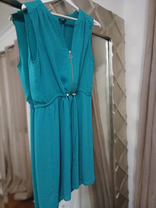 Vestido azul esverdeado, veste pequeno, ligeiramante abaixo do joelho,