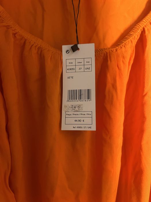 Tunica nova com etiqueta laranja e amarela