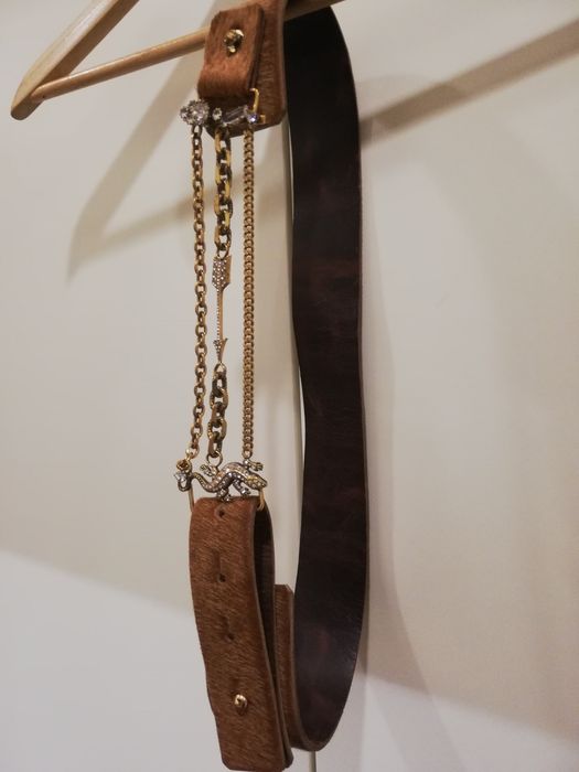 Cinto em pêlo camel, com aplicações douradas com brilhantes.