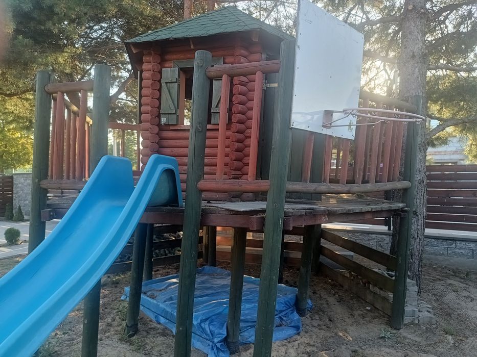 Domek dla dzieci, z zjeżdżalnią i piaskownicą.