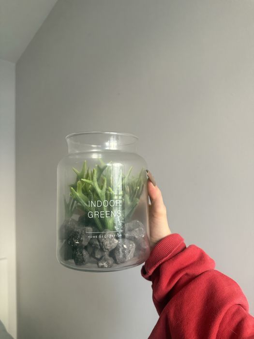 szklany wazon zawierający sztuczne rośliny i kamienie