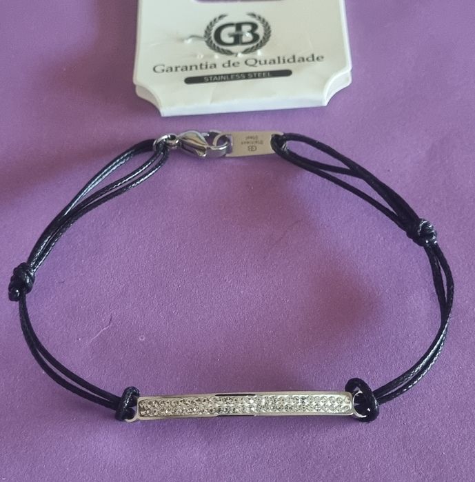 Pulseira preta e prateada, em aço. Chapinha com 2 fiadas de zirconias. Ajustável