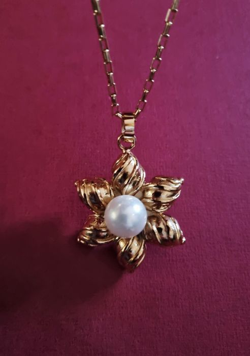 Colar dourado, em aço, flor com pérola. Tem extensor