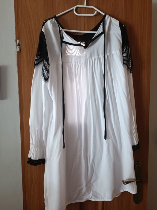 Tunika biala z czarnym ażurowym wykończeniem.