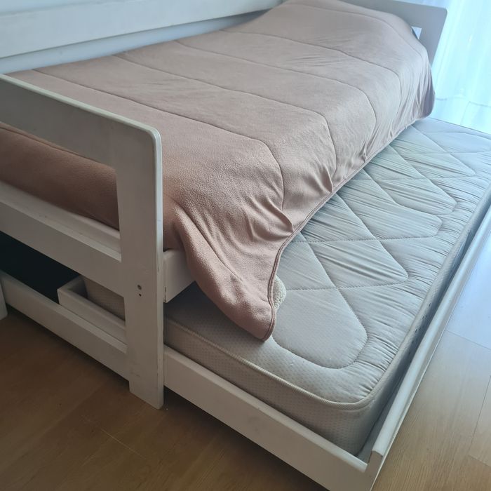 Cama de solteiro, branca, com gavetão em baixo.