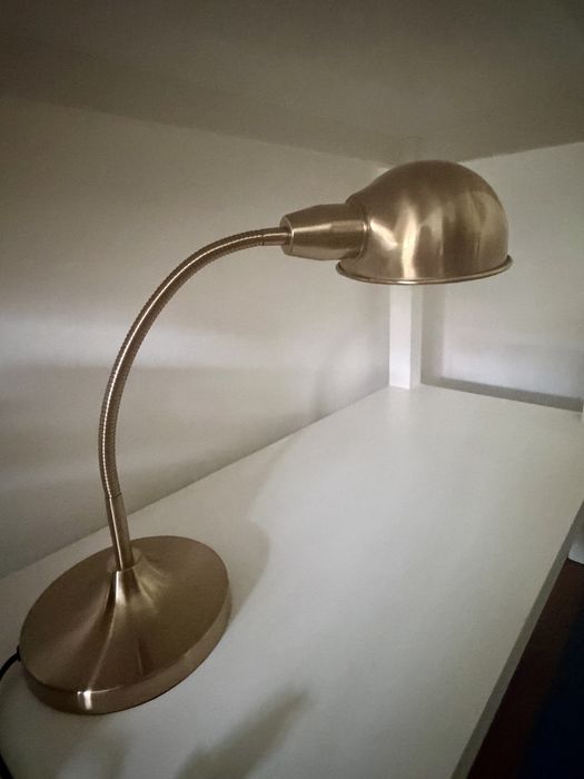 Candeeiro de secretária dourado, elegante e funcional.