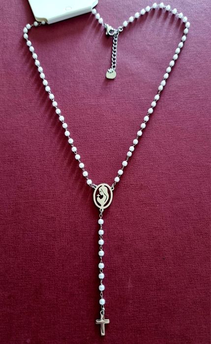 Colar prateado, em aço, em forma de terço com pequenas pérolas.