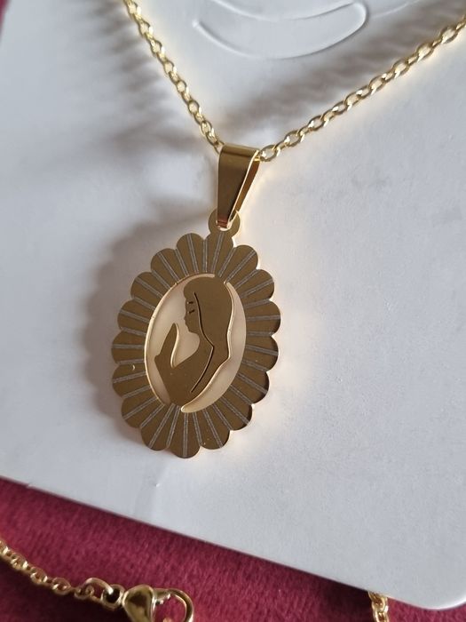 Colar prateado/dourado, em aço, com pingente da Nossa Senhora. Tem extensor