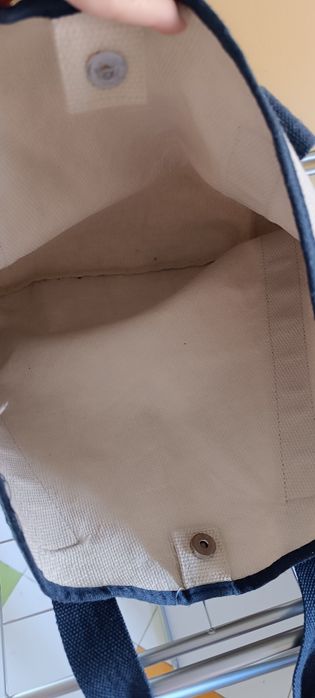 Saco de tecido bege e azul usado.