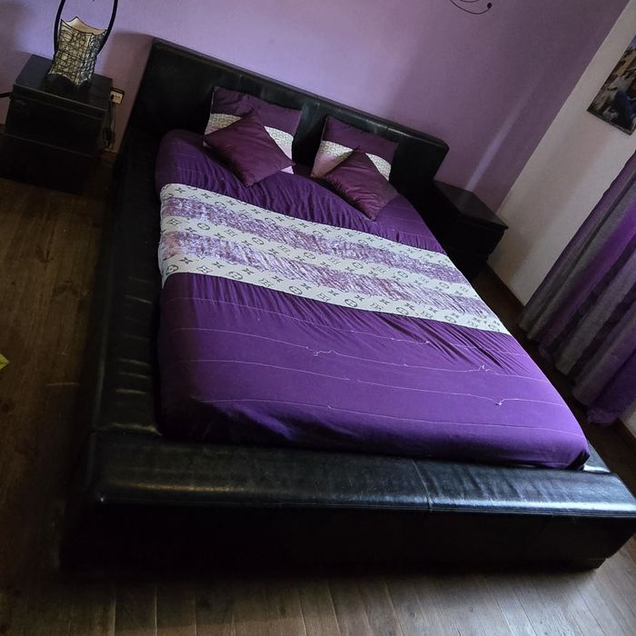 Cama preta com 2 mesas de cabeceira