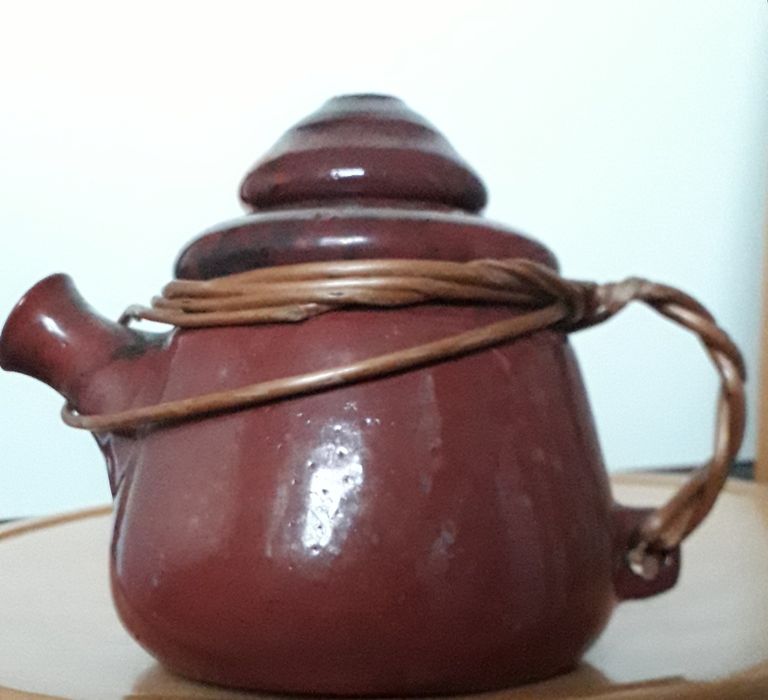 Ceramiczny dzbanek z oplotem wiklinowym.