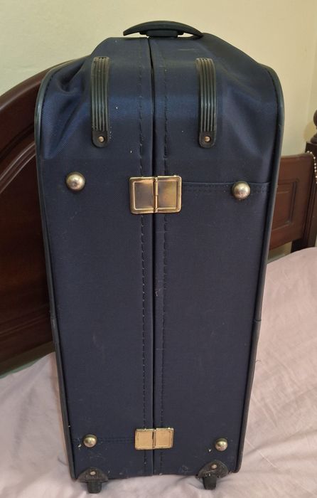 Mala de viagem azul com detalhes dourados