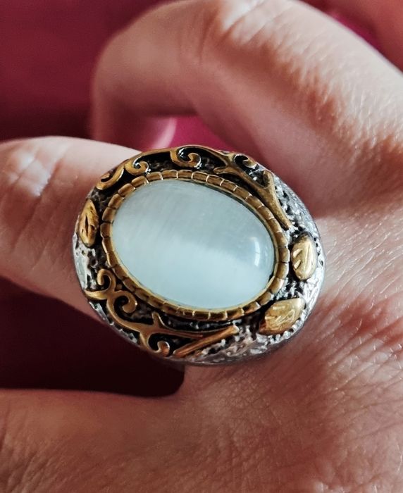 Anel bicolor, em aço, com grande pedra oval "olho de gato". T19/20