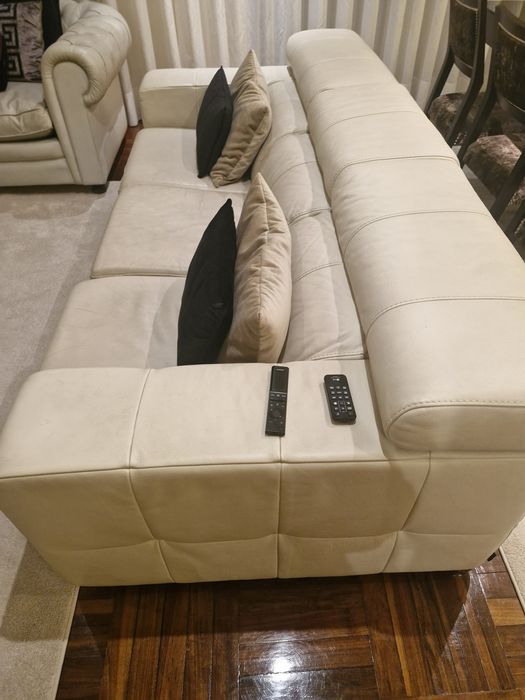 Sofá três lugares em pele beje.