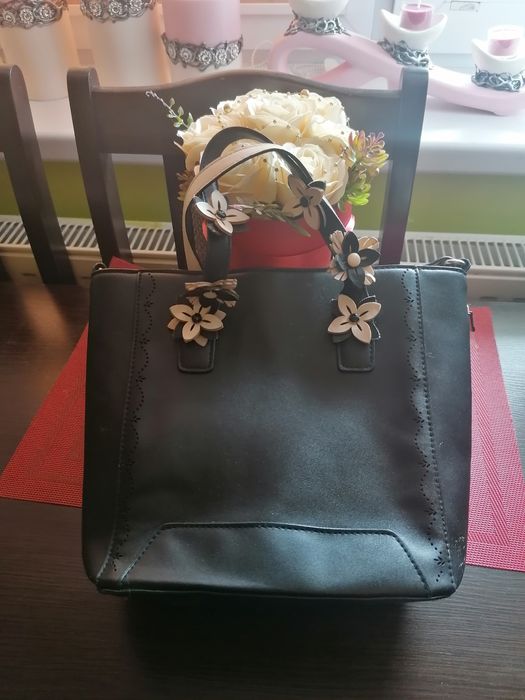Czarna torebka z  kwiatami.