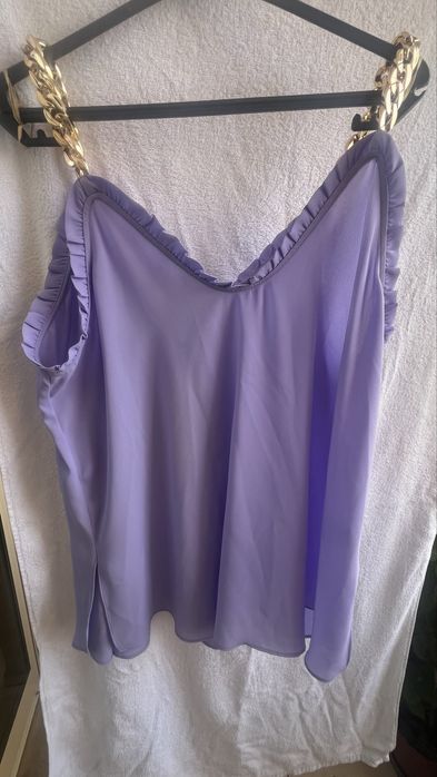 Blusa com alças de metal douradas.