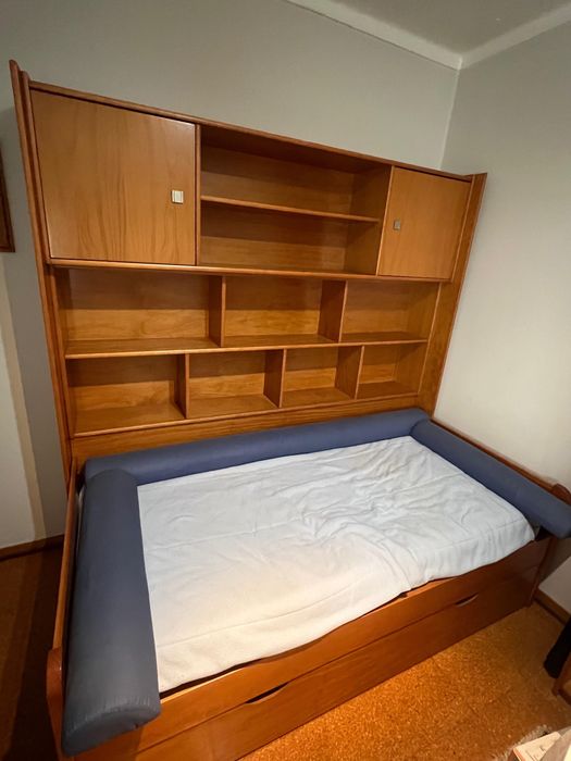 Cama individual com móvel associado com gaveta e colchão.