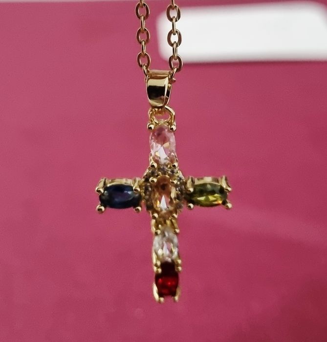 Colar dourado, em aço, com cruz colorida. Tem extensor