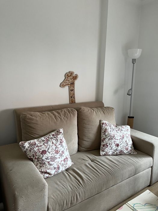 Sofá cama de dois lugares com marcas de uso
