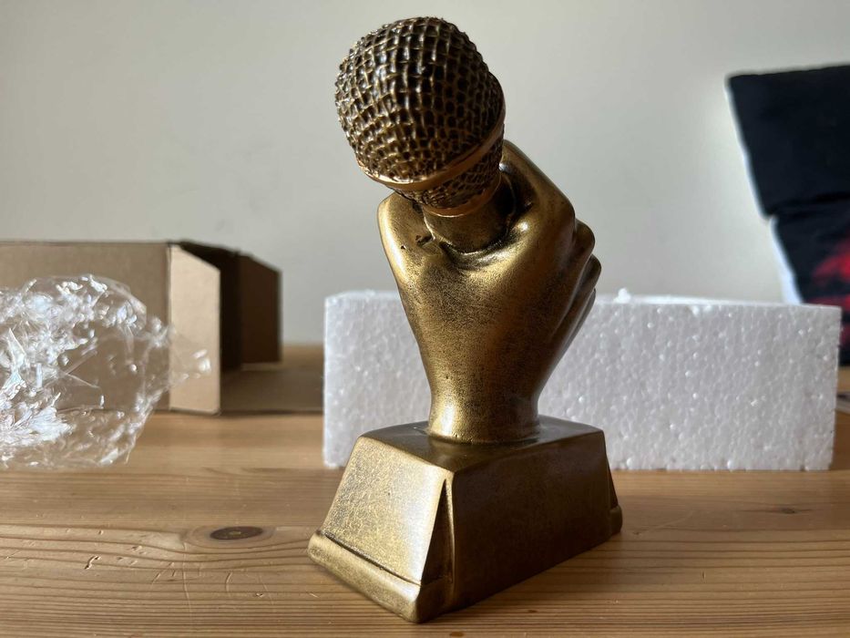 Trofeu mão com microfone dourado