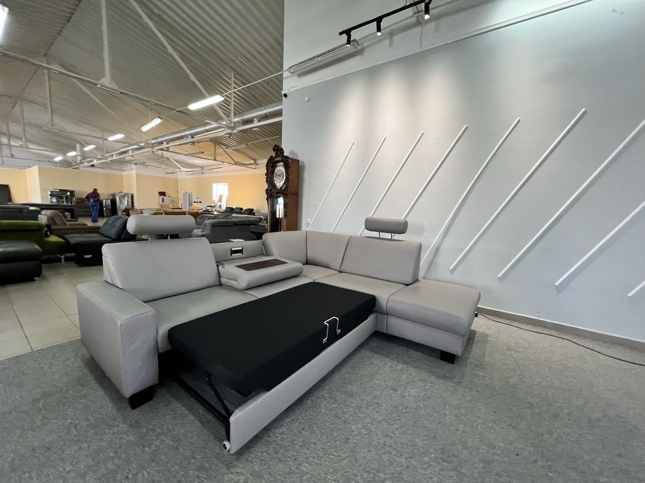 Виставковий кутовий світло сірий розкладний з нішами столиком шкіра