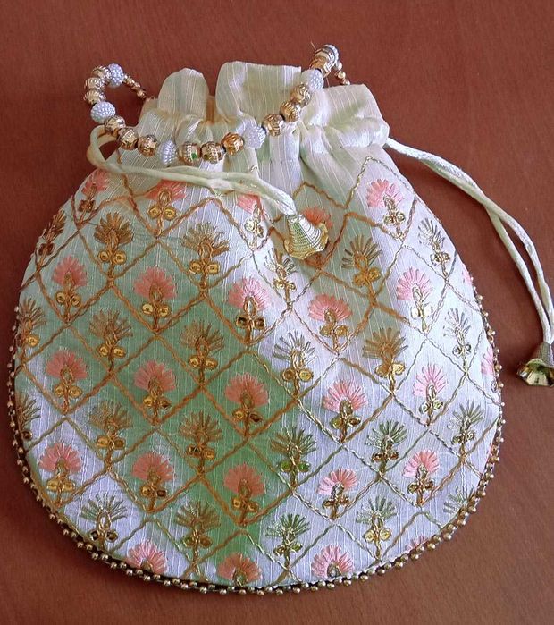 Delicada bolsa de mão branca com bordado floral dourado e coral