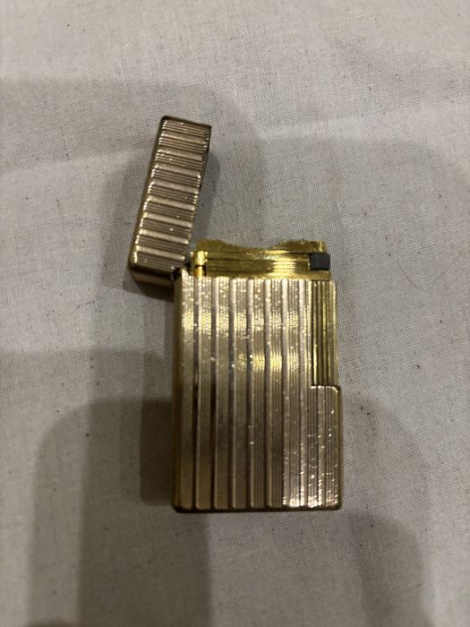 Vendo isqueiro de luxo vintage S.T. Dupont Paris, modelo clássico Ligne 1 com o icónico padrão guilloché de linhas verticais caneladas.