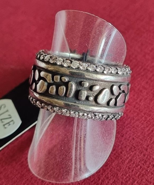 Anel prateado, em aço envelhecido, com fundo preto e zirconias. T18